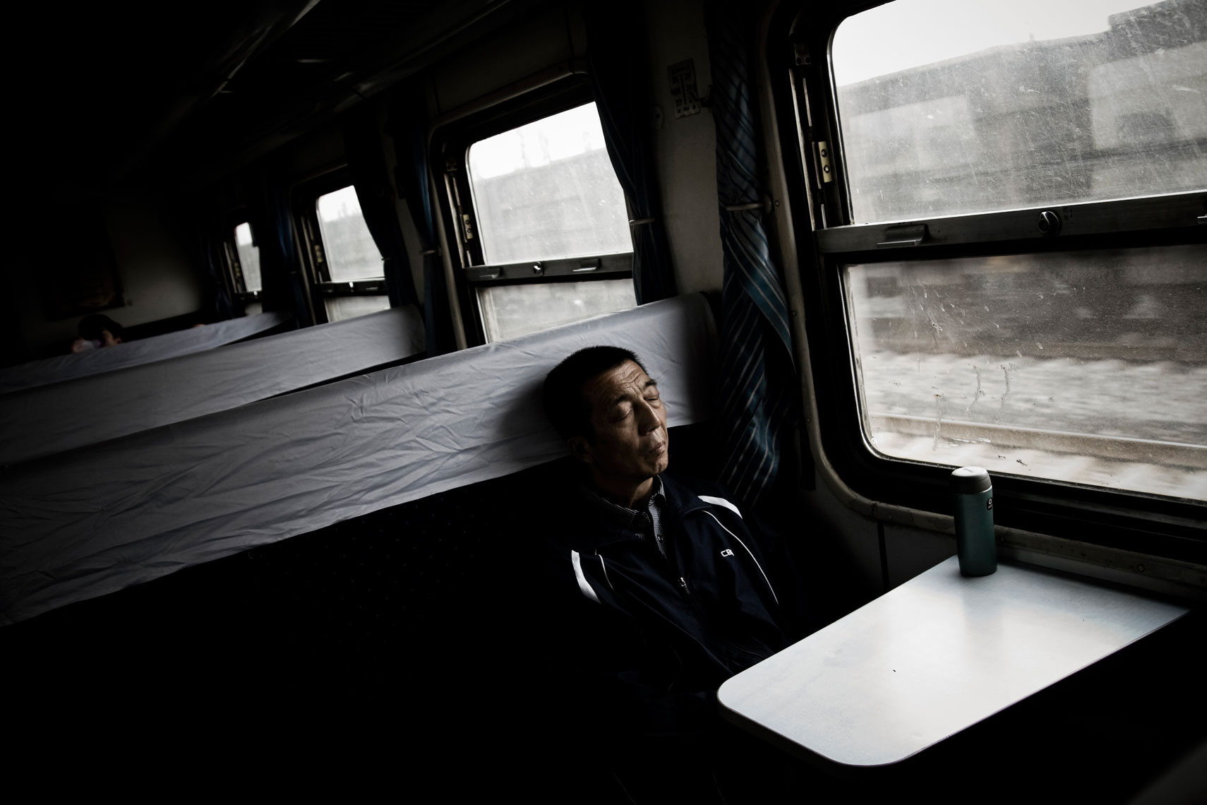 CHINA. Shanxi Province, September 2012. A man sleeping on the train that connects the cities of Datong and Ping Yao.
